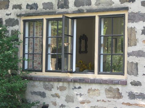 windows on a historic stone house porch with metal mullins|historical window replacement.